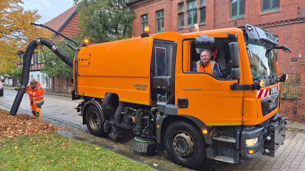 Steffen Linzenburg (rechts) und Alexander Kohnert sammeln das Laub aus der Stadt Haldensleben mit der Kehrmaschine ein.