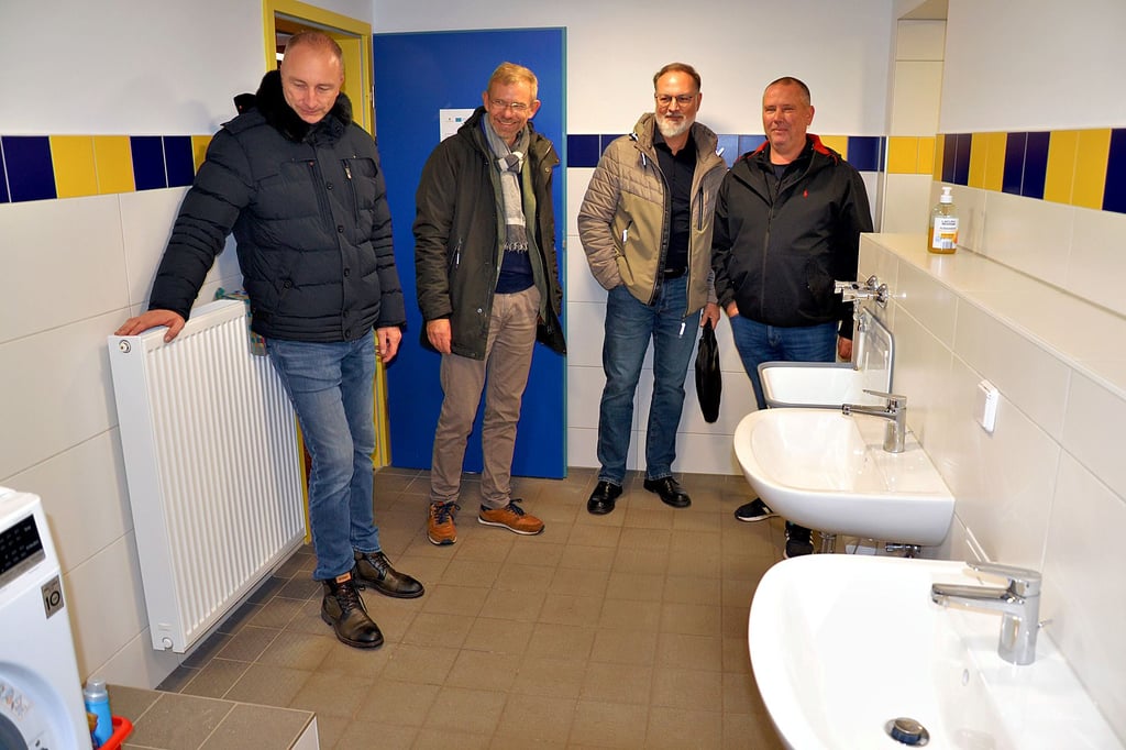 SVA-Präsident Stefan Lipke (r.) führt die Besucher durch die sanitären Anlagen am Altenweddinger Sportplatz. Die Duschen sind erst genau einen Monat alt.