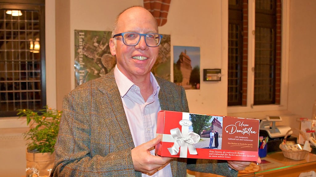 Pfarrer Teja Begrich zeigt einen der festlich verpackten Domstollen aus Havelberg.