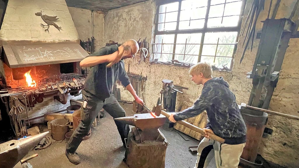 Peter Maas (links) arbeitet  mit einem der Besucher aus Tangermünde am Stahl.