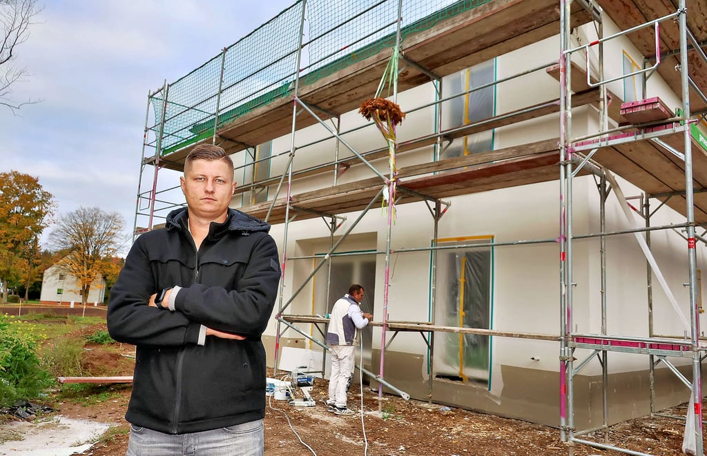 Fabian Wagner vor seinem neu gebauten Haus in der  Sangerhäuser Ostsiedlung. Er kann mit seiner Frau und seiner kleinen Tochter dort nicht einziehen, weil es Streit um den Anschluss an die Trink- und Abwasserleitungen gibt. 