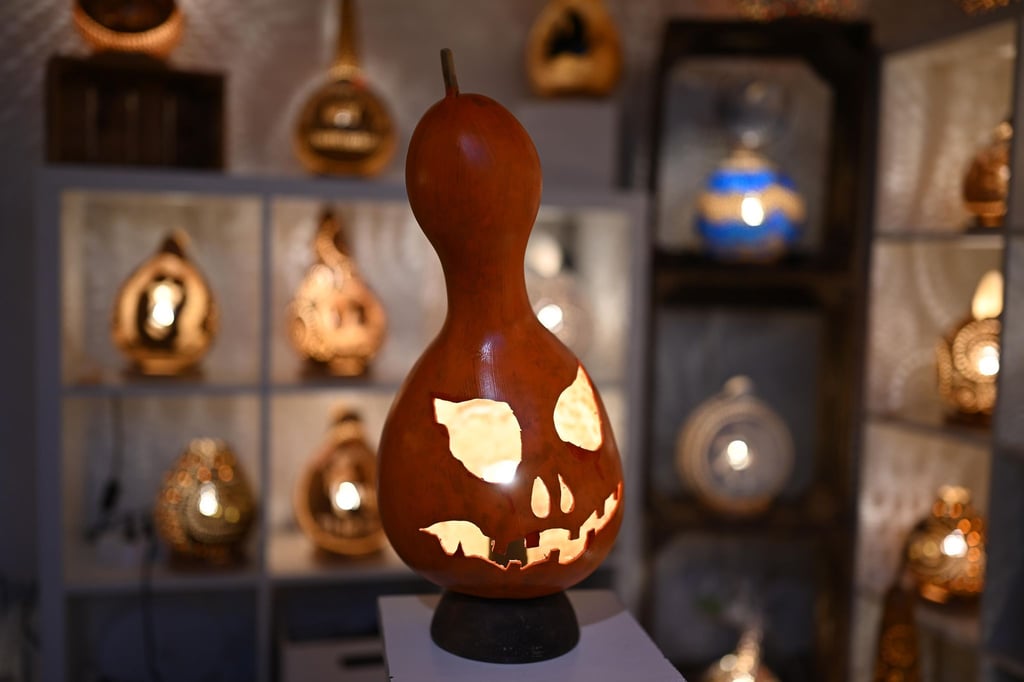 Eine handgefertigte Lampe aus einem Flaschenkürbis - mit Halloween-Fratze.