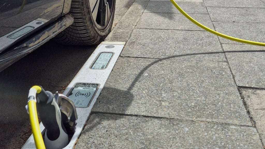 Ein Pkw parkt an einem Ladebordstein. Die E-Ladebordsteine sind ein Pilotprojekt der Stadt Köln. Der Einsatz soll nun auch in Magdeburg geprüft werden.