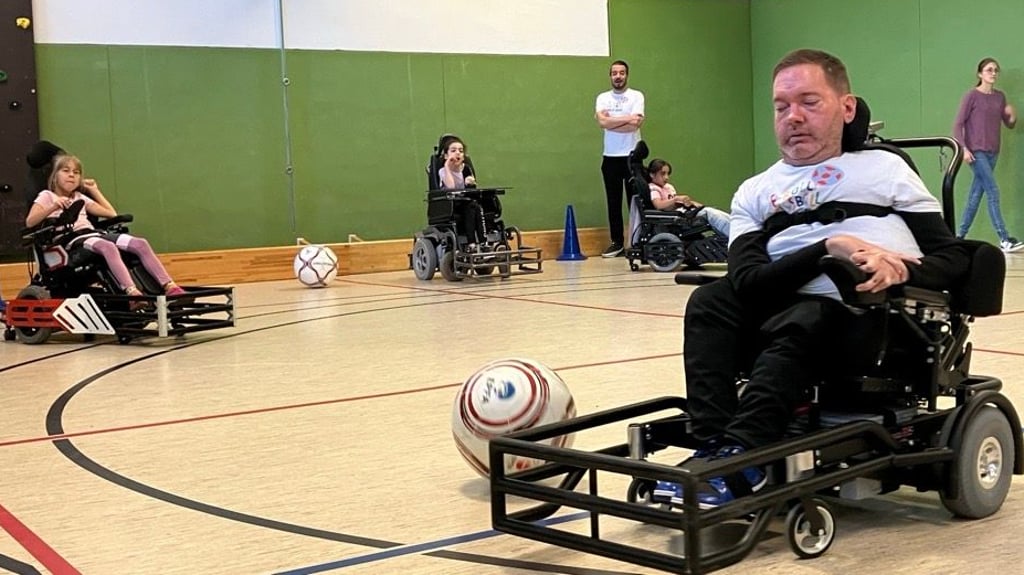Jörg Diehl (rechts) ist Nationalspieler im E-Rollstuhlfußball. Er hat den Kindern an der Carpe-Diem-Schule in Halle gezeigt, wie die Sportart funktioniert.