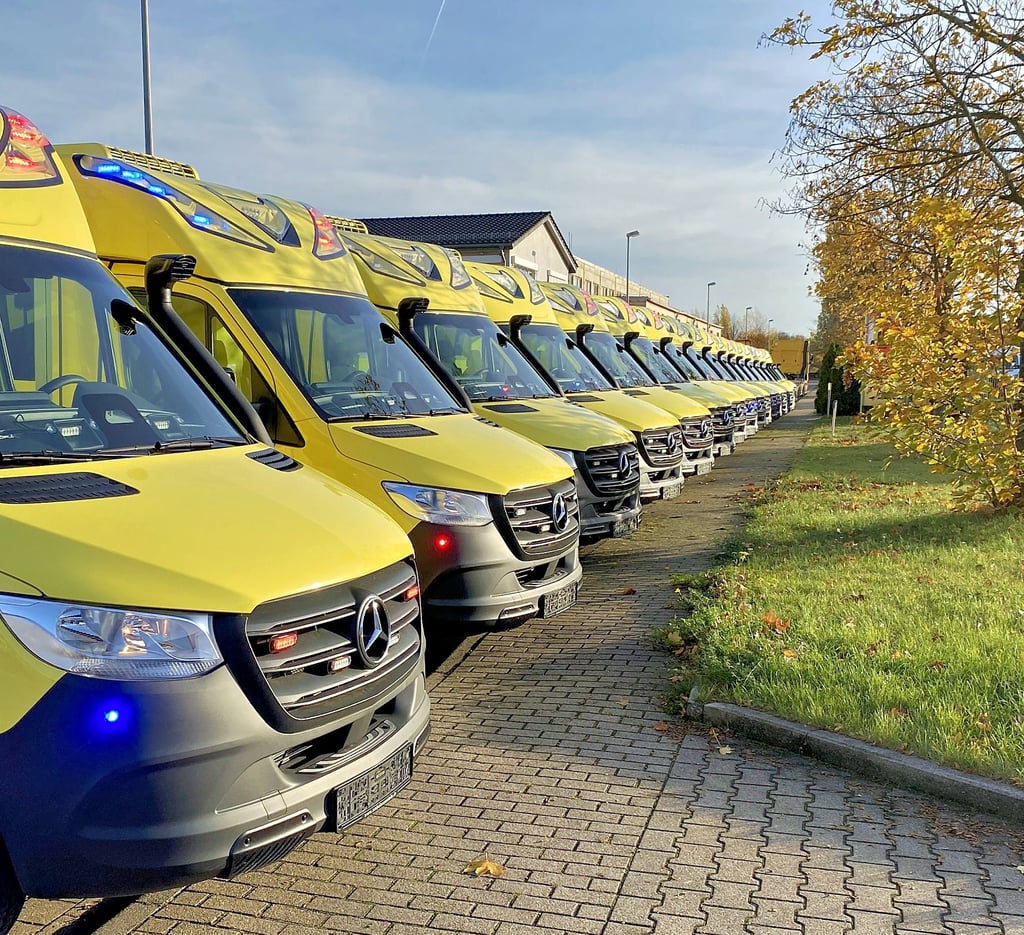 Die 18 Rettungswagen von Ambulanz Mobile für Abu Dhabi. Oben rechts ein Blick in das Modell mit zwei Tragen für den Transport von Frühchen und den Müttern. 
