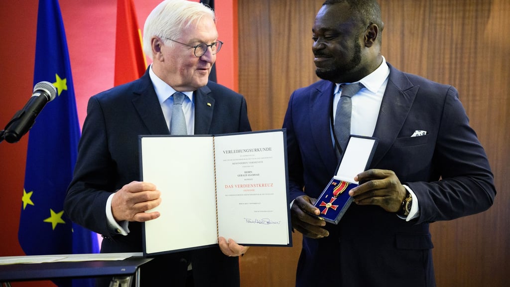 Der frühere Fußball-Nationalspieler Gerald Asamoah (r) erhält von Bundespräsident Frank-Walter Steinmeier das Bundesverdienstkreuz.