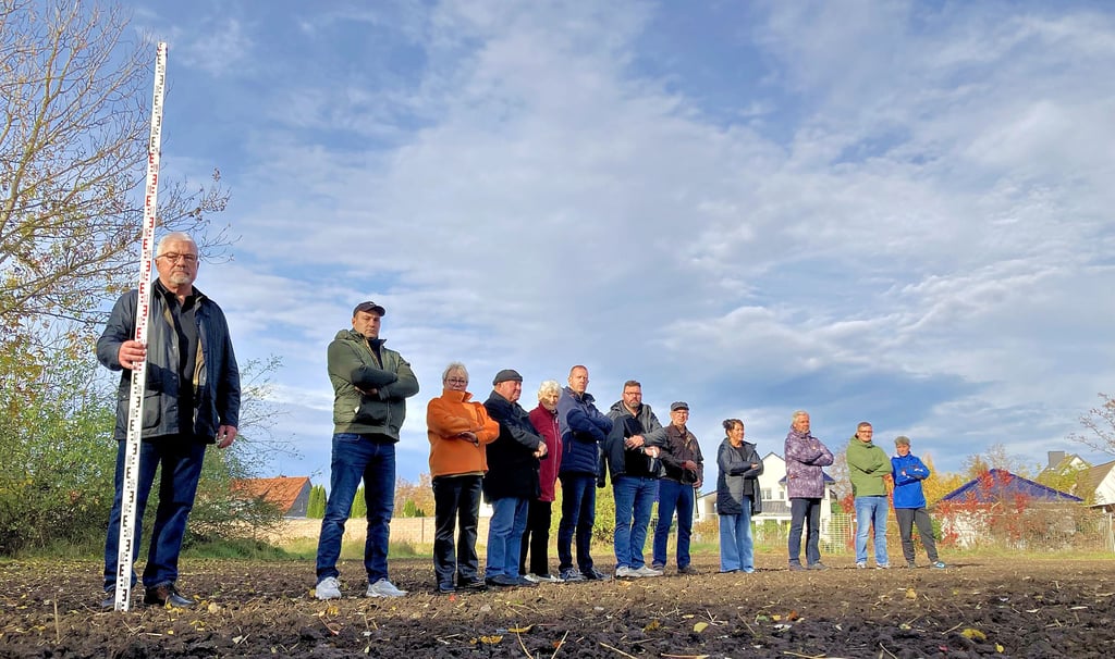 Dass der Solarpark gerade mal 55 Meter von den Grenzen ihrer Grundstücke entfernt errichtet werden soll, ärgert die Anwohner der Maxim-Gorki-Straße in Köthen. Mit einer Messlatte markiert Peter Pesth (l.) diesen Abstand sowie die Höhe der geplanten Solarmodule. 