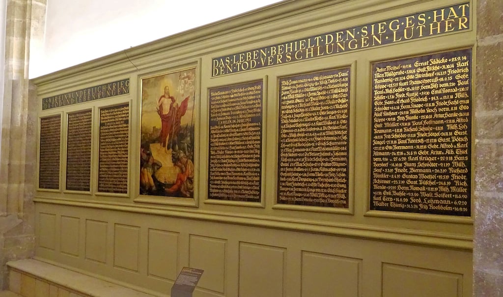 Zwölf Tafeln mit den Namen Gefallener, sechs auf jeder Seite, sind in der Wittenberger Stadtkirche zu sehen. Jeweils in der Mitte befinden sich ältere Gemälde. Diese zeigen die Kreuzigung Jesu sowie dessen Auferstehung. 