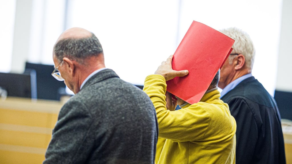 Zum Prozessauftakt verdeckte der Angeklagte sein Gesicht mit einem Ordner.