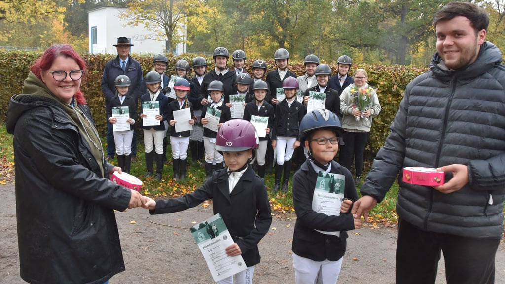 Im Vordergrund freuen sich Lasse Schmittke (r.) und Tabea Schmidt über ihre bestandenen Reitabzeichen – beglückwünscht werden sie von Maren Braumann und Tjark Wolterstorf. Im Hintergrund zu sehen sind Richter Karl Wenzel sowie die weiteren erfolgreichen Teilnehmer des Lehrgangs des Freizeitreit- und Fahrvereins „Neun Eichen“.