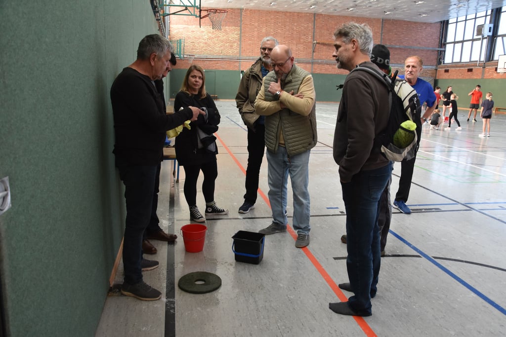 Besprechung in der Turnhalle mit VfL-Vorstand, Bürgermeister und Unternehmern. Hinten trainiert derweil der Leichtathletik-Nachwuchs.