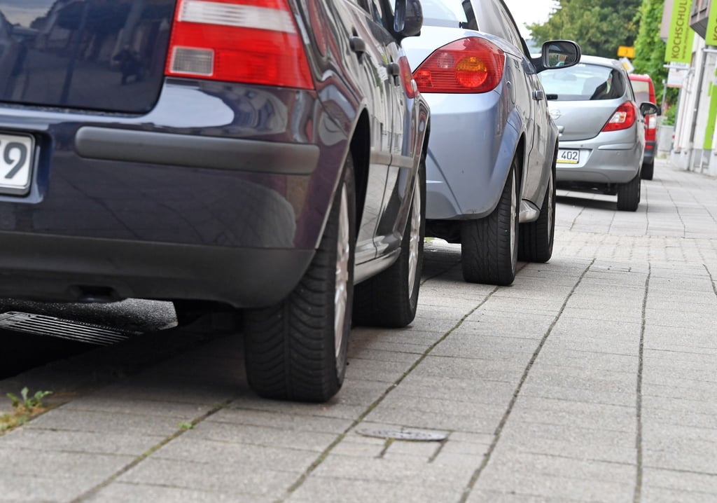 Auf Gehwegen parkende Autos versperren Rollstühlen oder Kinderwagen häufig den Weg. (Symbolbild)
