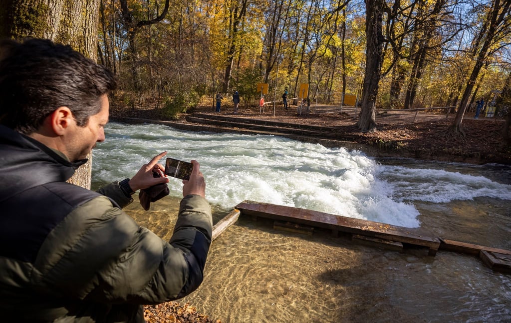 Freizeitsurfer Alexander Neumann fotografiert die - zurzeit nicht funktionstüchtige - Eisbachwelle im Englischen Garten.
