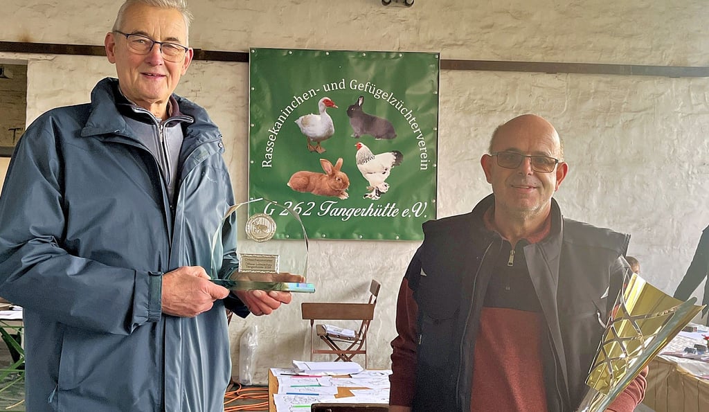 Ortsbürgermeister Gerhard Borstell und Vereinsvorsitzender Peter Komnick mit Pokalen für die besten Tiere.