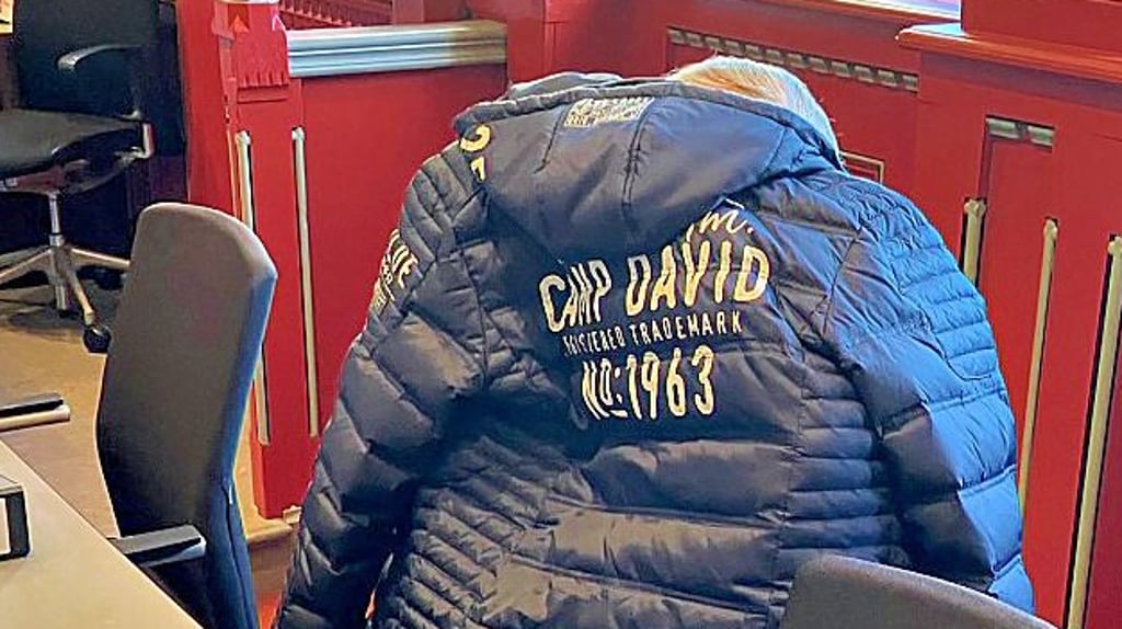 Der angeklagte Großvater im Saal 123 des Landgerichts versteckt sich hinter seiner Jacke. 