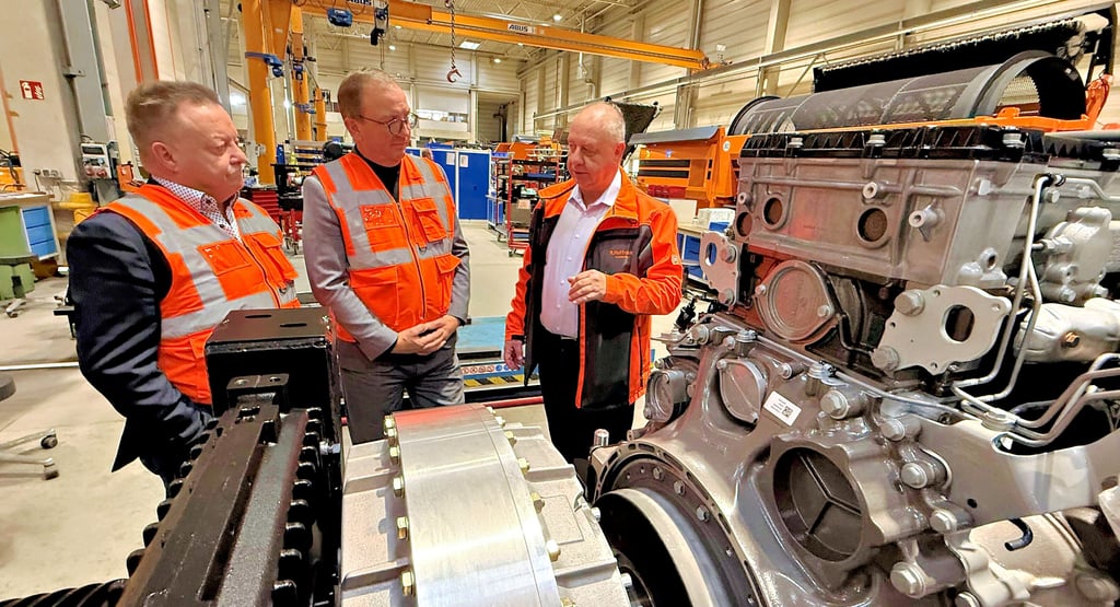 Fachdienstleiter Tilo Wechselberger (v. l.), Landrat Markus Bauer und Doppstadt-Geschäftsführer Reimund Hoffmann vor einem Motor, der eine mobile Recyclinganlage des Unternehmens antreibt.