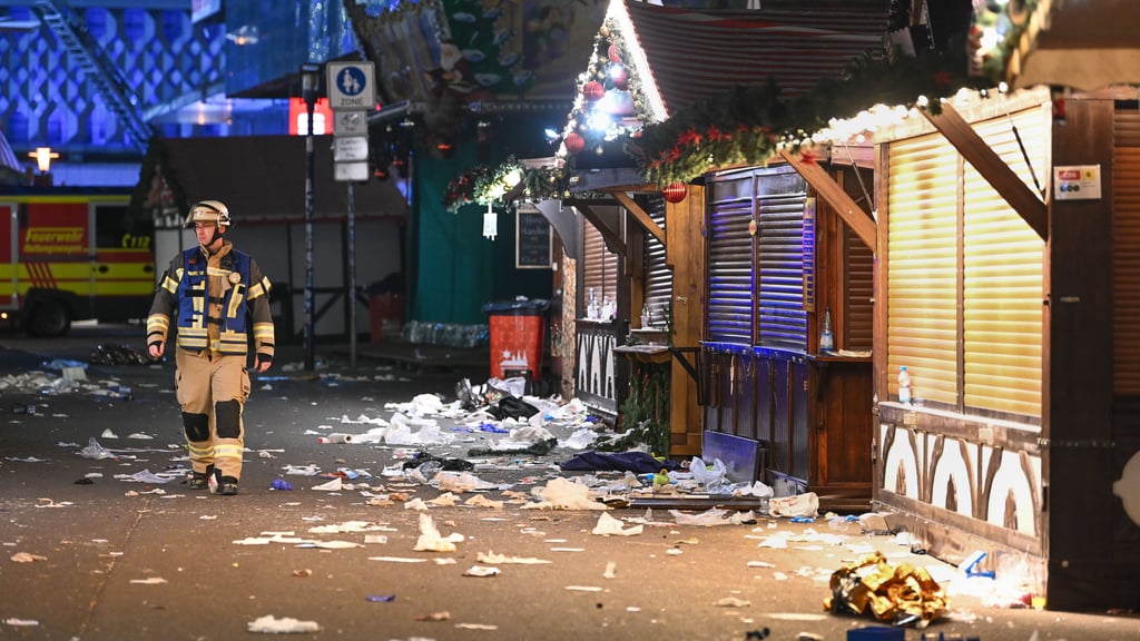 Ein Feuerwehrmann geht durch die Gasse, durch die der Attentäter am 20. Dezember 2024 auf dem Weihnachtsmarkt in Magdeburg raste.