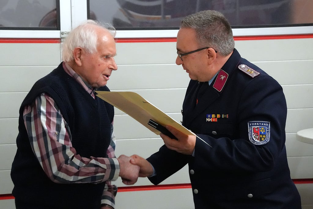 Kreisfeuerwehrverbandsvorsitzender Steffen Jorns (rechts) gratuliert Karl Zabel zur Auszeichnung.