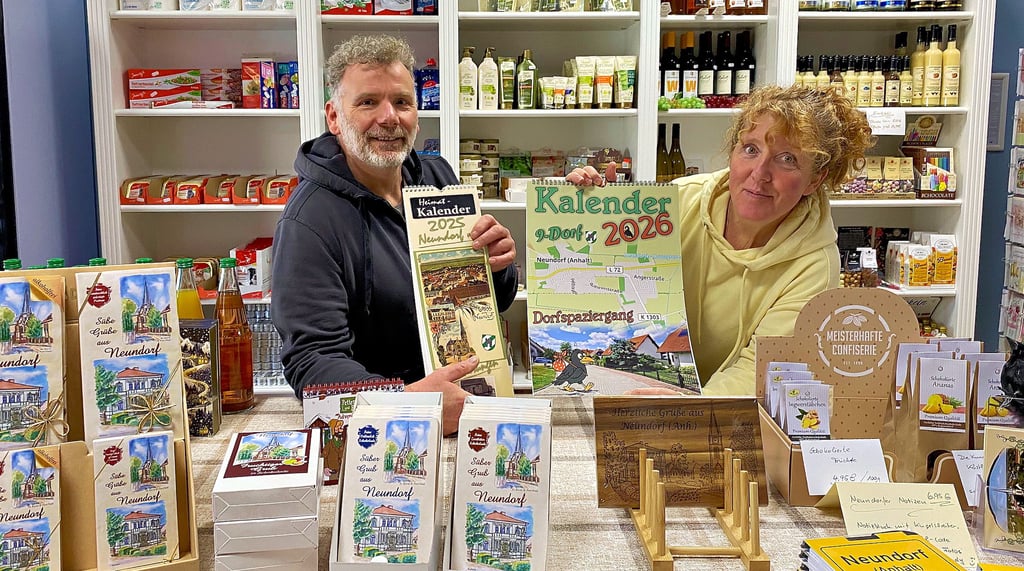 Florian und Heike Stops vom  9-Dorf-Laden zeigen den alten und den neuen Kalender – dieses Jahr mit Rezepten, 2026 als Dorf-Spaziergang.