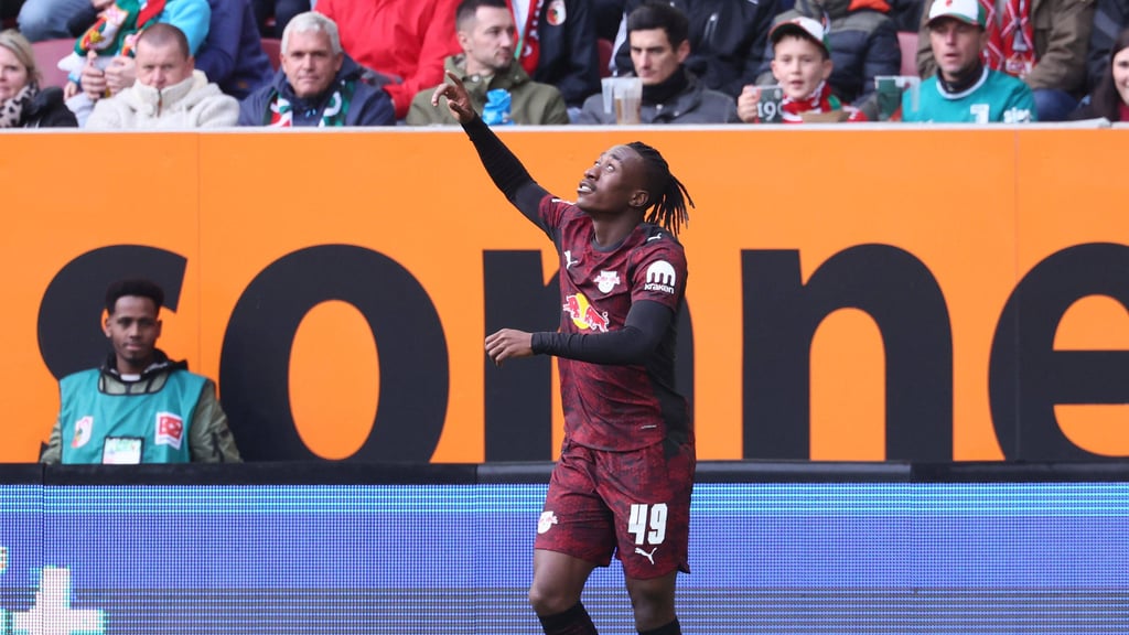 Yan Diomande zeigt nach seinem Tor gegen Augsburg zum Himmel.