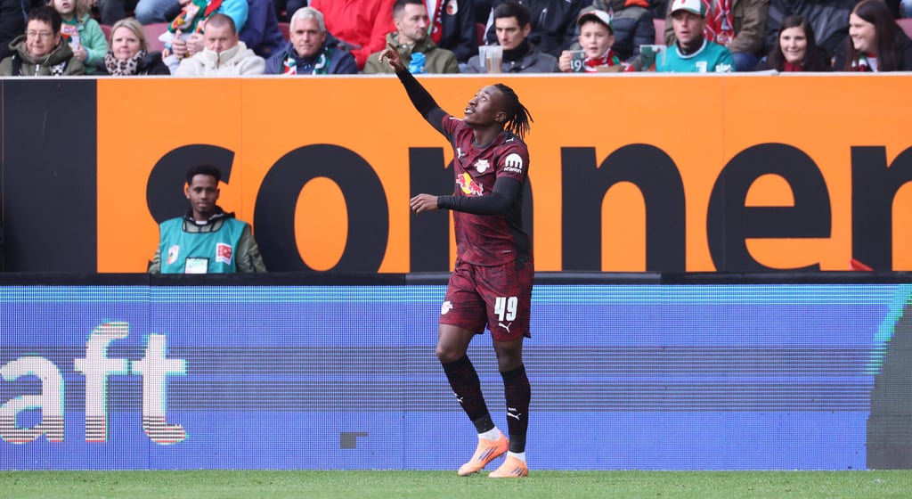 Yan Diomande zeigt nach seinem Tor gegen Augsburg zum Himmel.