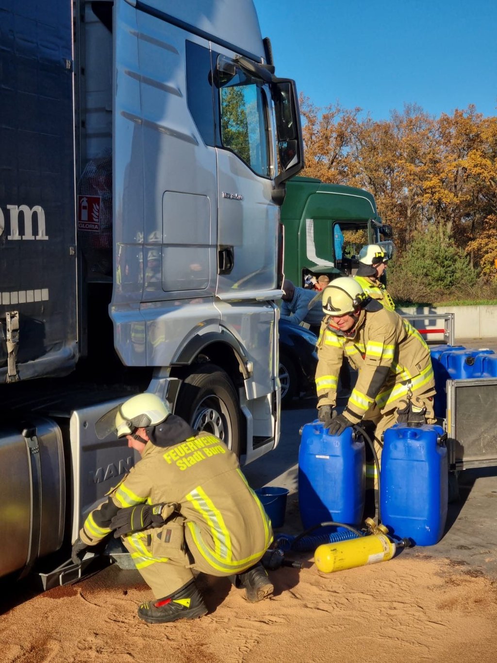 Einsatzkräfte der Feuerwehr aus Burg haben auf einem Parkplatz an der Autobahn 2 aus einem aufgerissenen Tank eines LKW Betriebsstoffe umgefüllt.