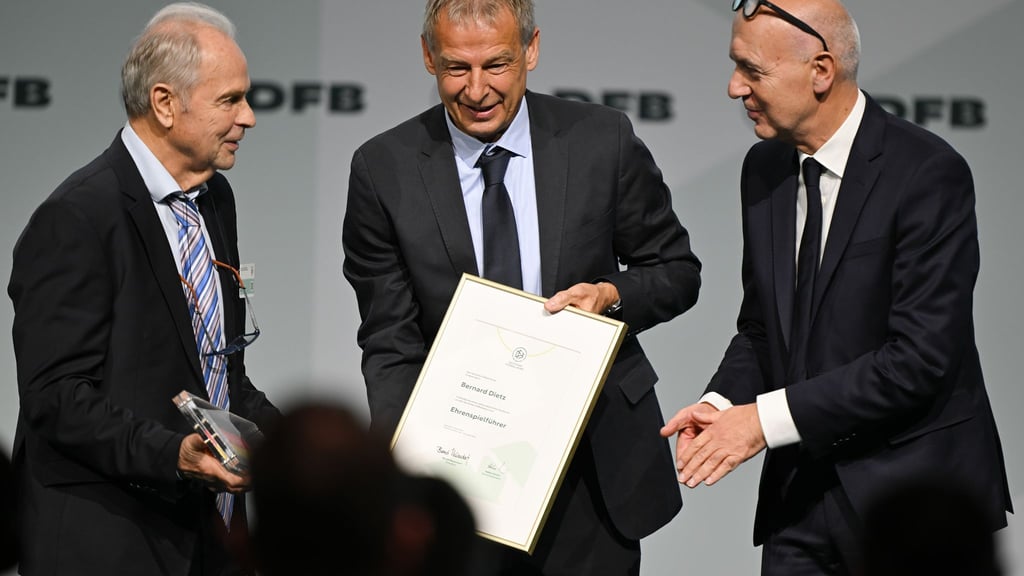 Bernard Dietz (l) wird von Jürgen Klinsmann und DFB-Präsident Bernd Neuendorf für die Ernennung zum Ehrenspielführer gratuliert.