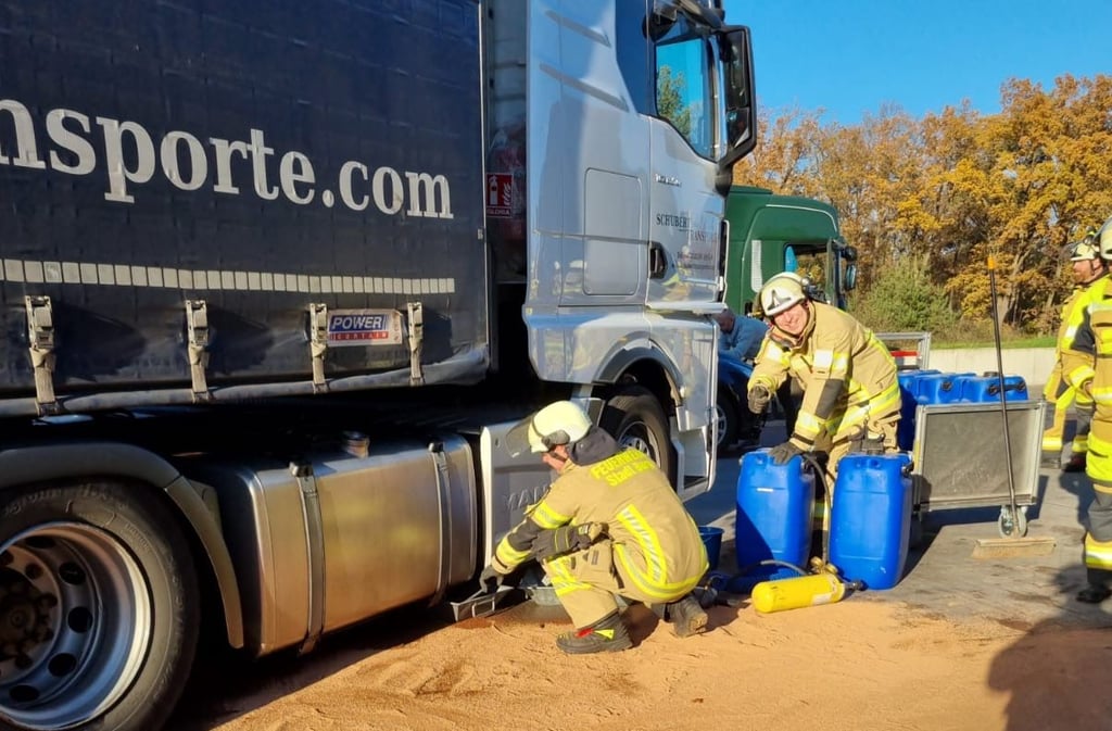 Einsatzkräfte der Feuerwehr aus Burg haben auf einem Parkplatz an der Autobahn 2 aus einem aufgerissenen Tank eines LKW Betriebsstoffe umgefüllt.