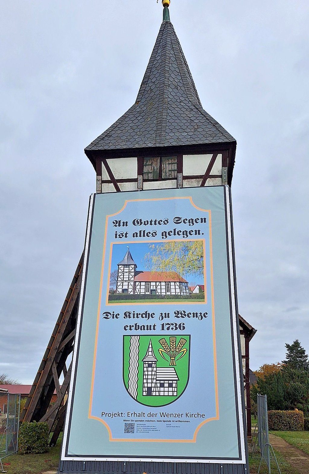 Der Wenzer Glockenturm ist seit einigen Tagen mit einer Werbeplane eingerüstet. So soll Geld für die Sanierung gesammelt werden. 