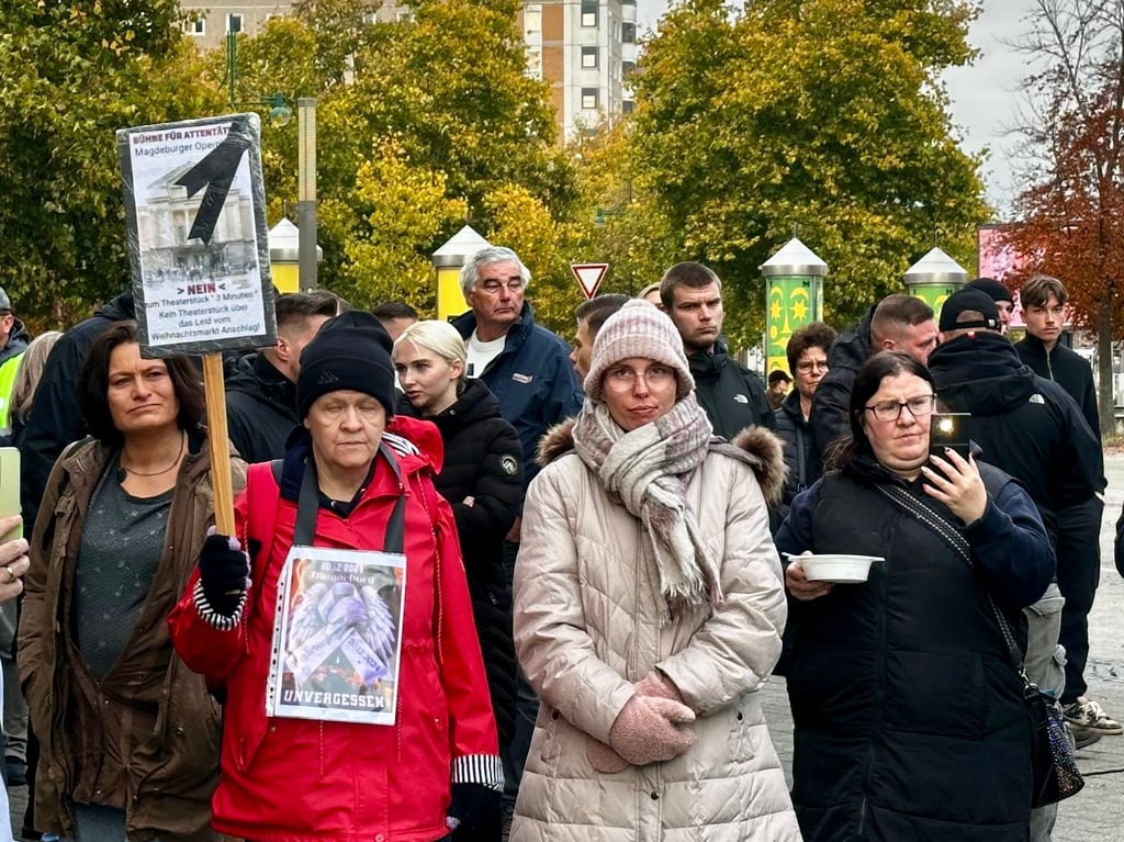Mehrere Menschen kamen mit Plakaten zur Demonstration am Opernhaus Magdeburg gegen das Stück "3 Minuten".