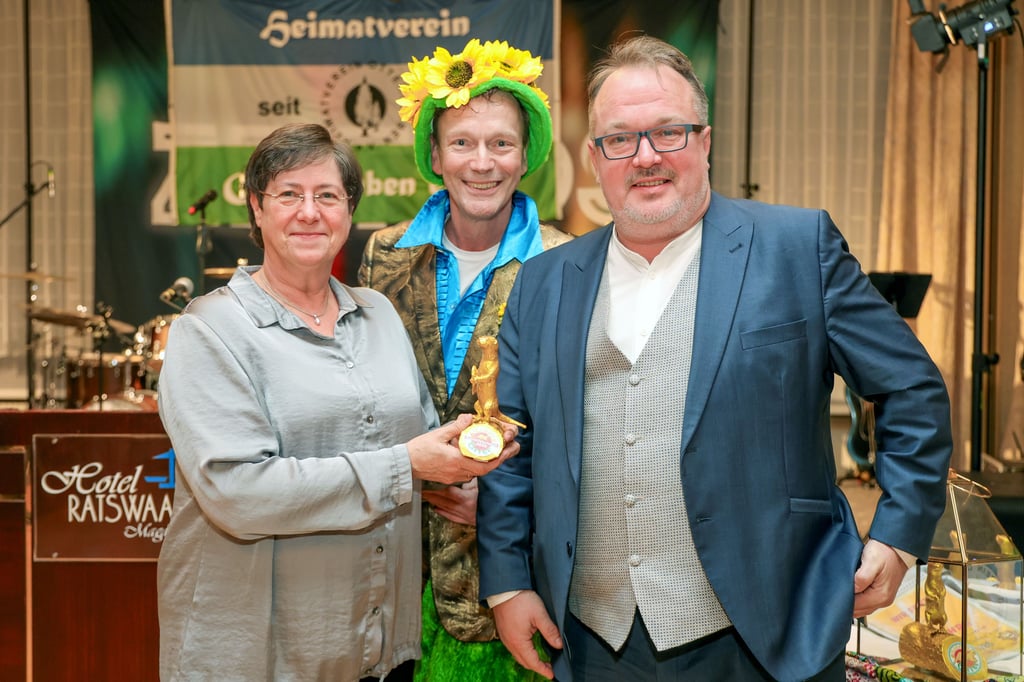 Andrea Schwenke und Christian Scharf (r.) nahmen von Initiator Holger Paech den „Goldenen Otter“ für den Kartoffelschälwettbewerb zum Ottersleber Volks- und Heimatfest entgegen.