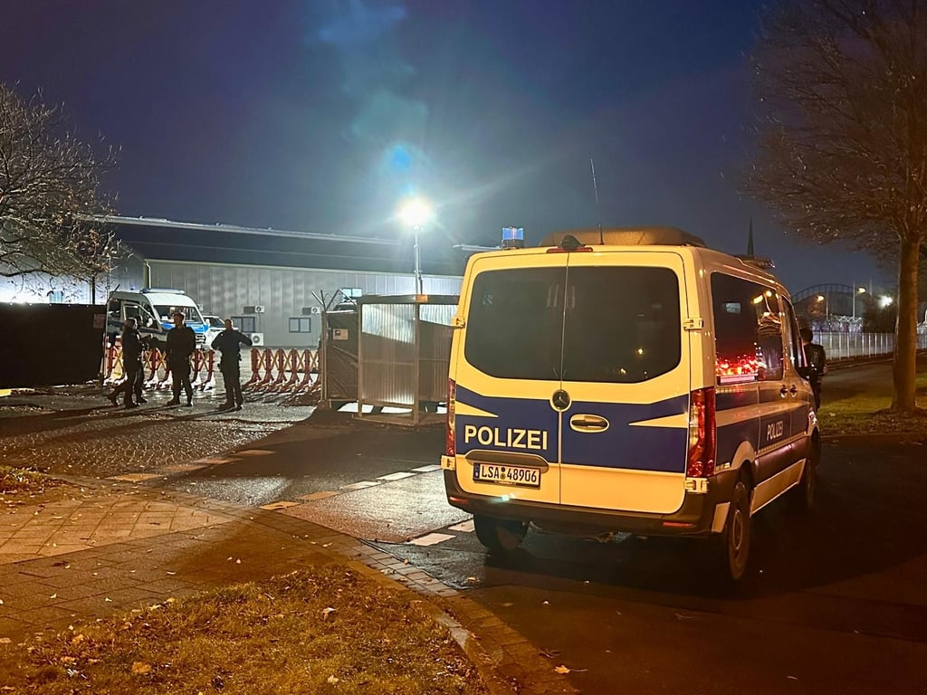 Ein Polizeiwagen steht vor dem Gericht in Magdeburg. Fahrzeuge werden kontrolliert.