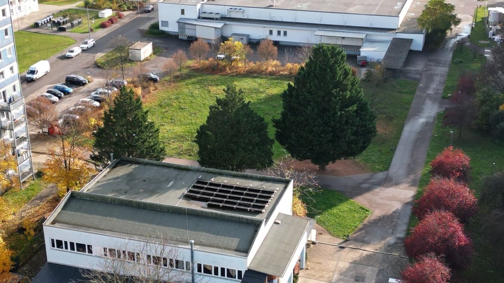 Im Vordergrund das alte IKC-Gebäude, in der Mitte die Freifläche vor dem Supermarkt, auf der der Neubau entstehen soll.