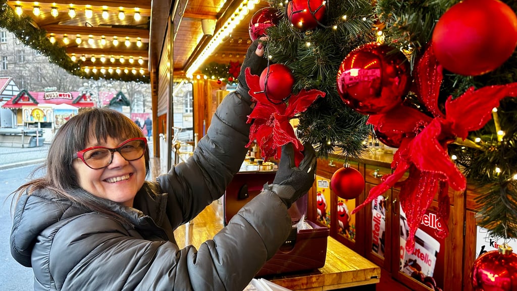 Gute Miene zum bösen Spiel: Dekorateurin Conny Bachmann gestaltet einen Stand auf dem Magdeburger Weihnachtsmarkt. Doch die Angst schwingt mit, morgen schon wieder alles abbauen zu müssen.