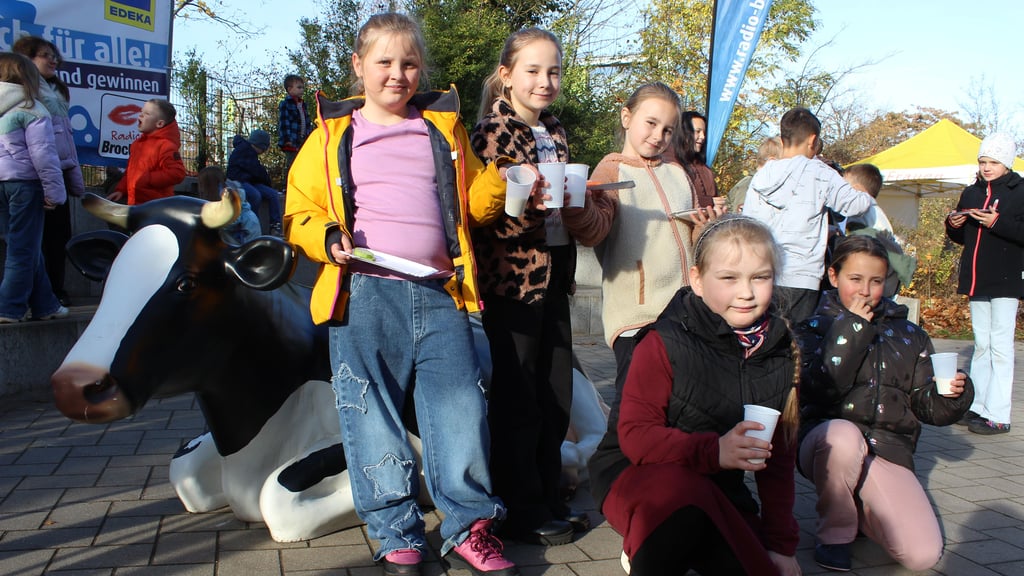 Die Schülerinnen Helene (von links oben), Thea, Elisa, sowie Mara und Florentina (unten) trinken frische Kuhmilch auf dem Schulhof der Erich-Kästner-Grundschule.