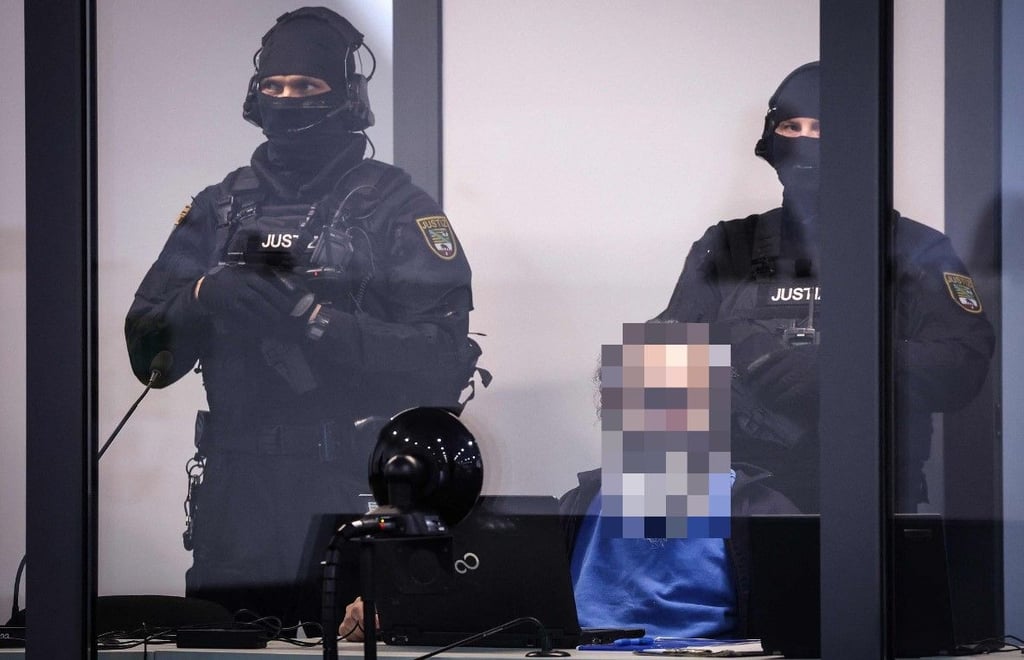 Gefesselt und in einem schusssicheren Kasten verfolgt Taleb A. den Prozess gegen ihn.