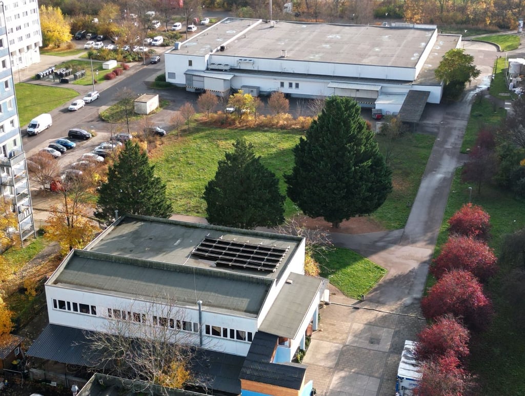 Im Vordergrund das alte IKC-Gebäude, in der Mitte die Freifläche vor dem Supermarkt, auf der der Neubau entstehen soll.