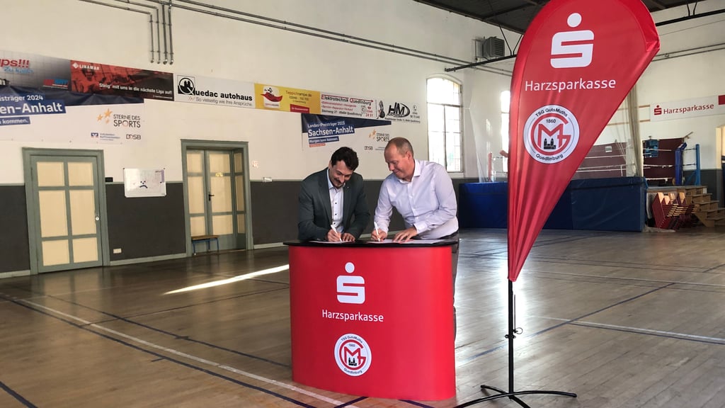 Auf dem neuen Counter, mit dem sich die TSG GutsMuths Quedlinburg künftig bei Veranstaltungen präsentieren kann, unterschreiben Sparkassenvorstand Haiko Elschner (l.) und Vereinsvorsitzender Frank Müller (r.) den Kooperationsvertrag.