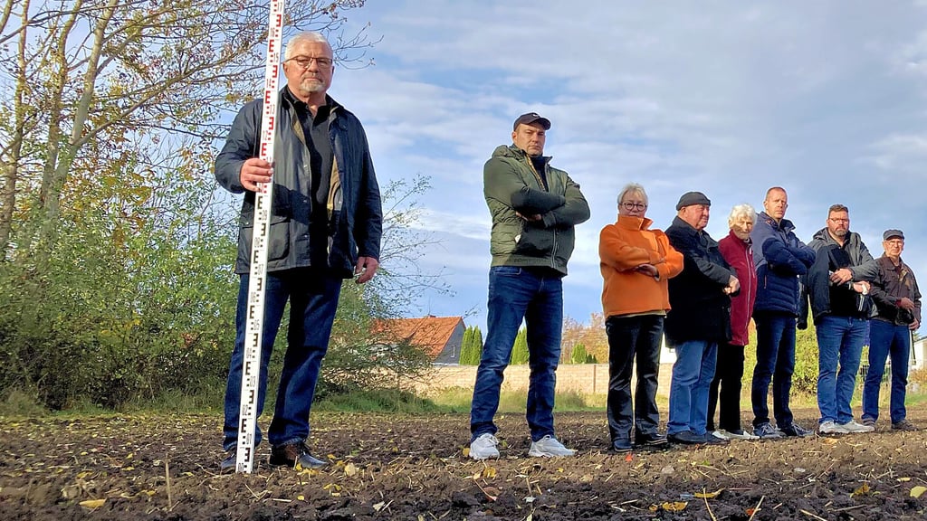 Dass der Solarpark gerade mal 55 Meter von den Grenzen ihrer Grundstücke entfernt errichtet werden soll, ärgert die Anwohner der Maxim-Gorki-Straße in Köthen. Mit einer Messlatte markiert Peter Pesth (l.) diesen Abstand sowie die Höhe der geplanten Solarmodule. 