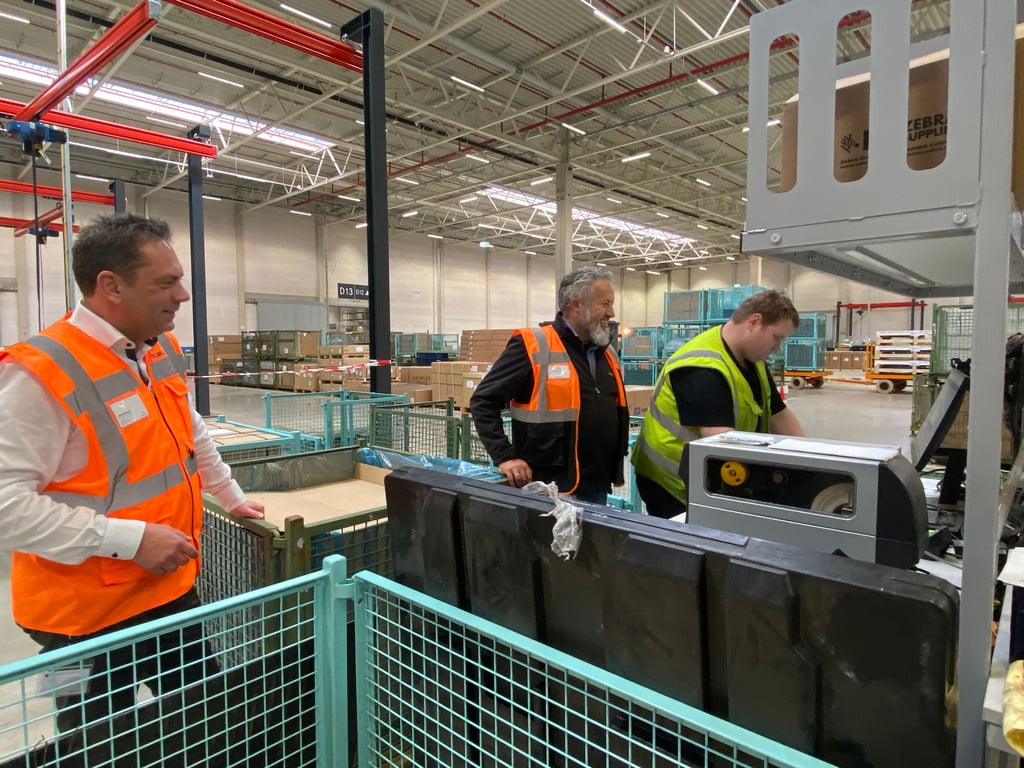 Jan Lohrengel (links) und Bert Geuens (Mitte) in den Lagerhallen des Global Parts Center von Daimler Truck in Halberstadt.