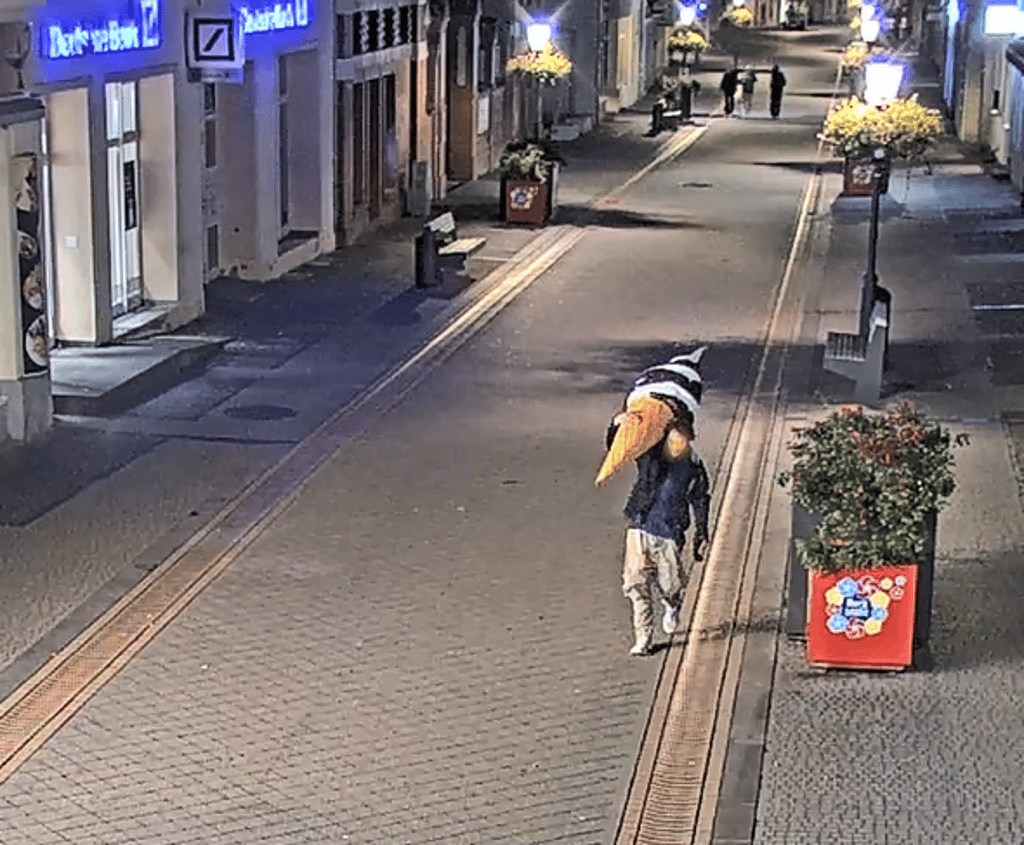 Scheinbar seelenruhig trägt ein junger Mann eine XXL-Eistüte durch die Innenstadt von Burg, die von der Polizei videoüberwacht wird.