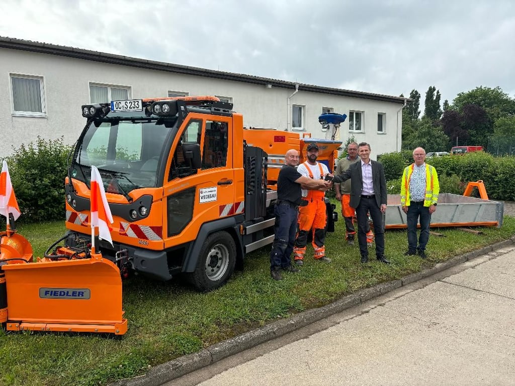 Oscherslebens Bürgermeister Benjamin Kanngießer (2. von rechts) bei der Übergabe eines Multicar an die Mitarbeiter des Bauhofs