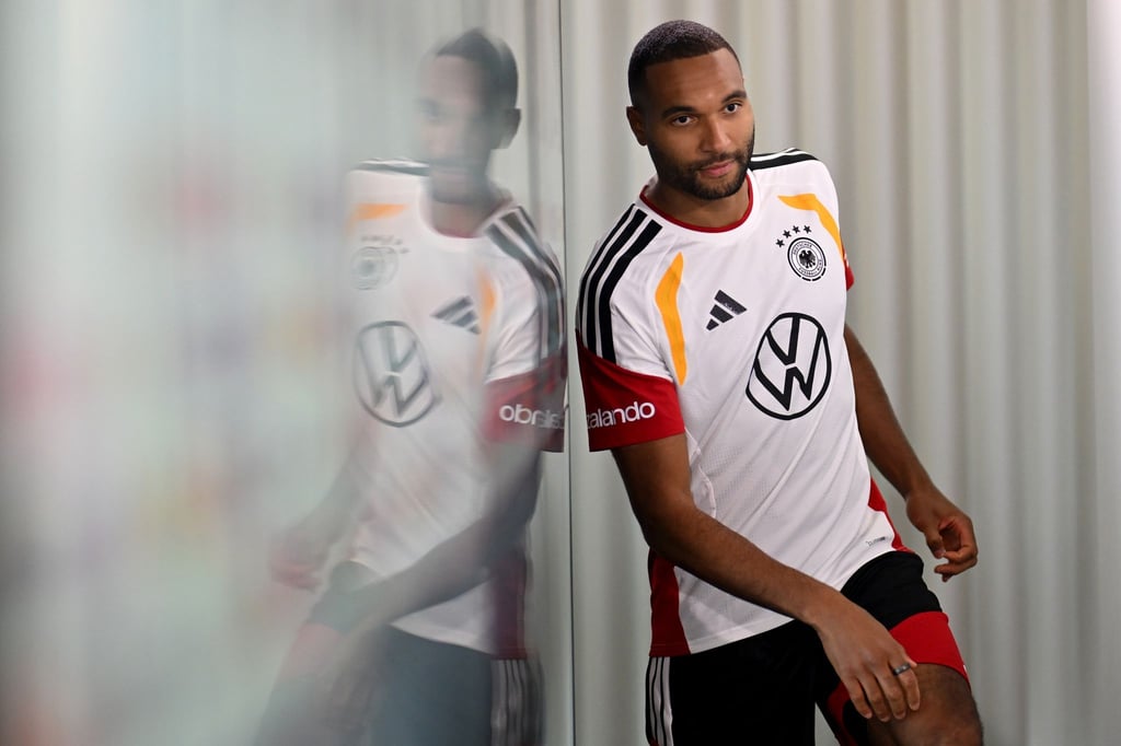 Schwungvoll betritt Tah das DFB-Podium.