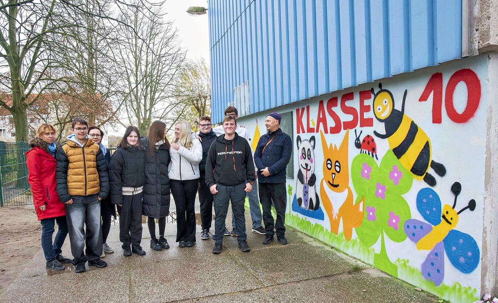 Die Zehntklässler haben mit Graffiti eine Außenwand der Pestalozzischule neu gestaltet. Ganz rechts im Bild ist der Künstler Jakob Wolf.