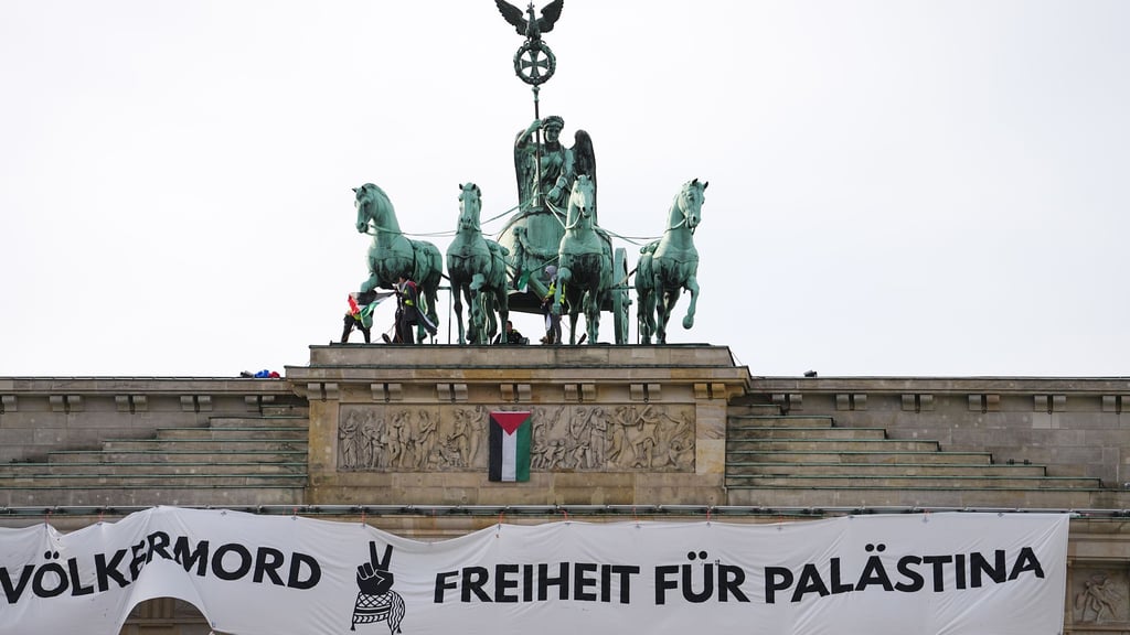 Mehrere Demonstranten sind auf das Brandenburger Tor in Berlin geklettert und haben ein israelfeindliches und propalästinensisches Transparent aufgehängt.