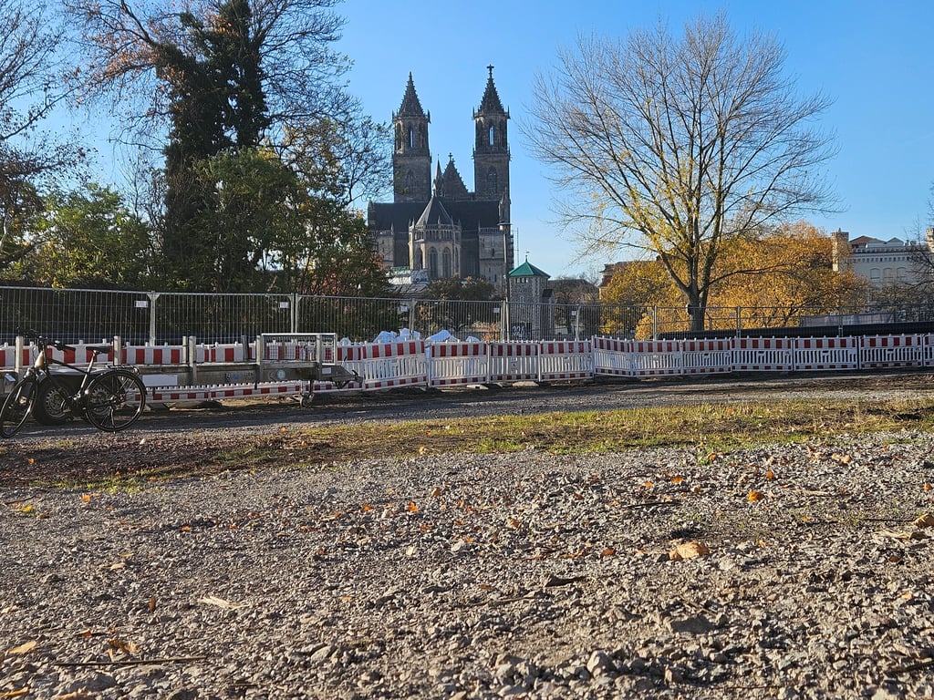 Blick über das Areal an der Schleusenstraße mit dem Magdeburger Dom auf der anderen Seite der Elbe. Die aktuellen Absperrungen gehören zu einer Baustelle der SWM.