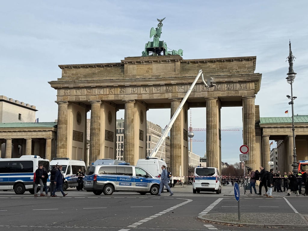 Die Polizei klettert auf das Brandenburger Tor in Berlin, um Demonstranten festzunehmen.