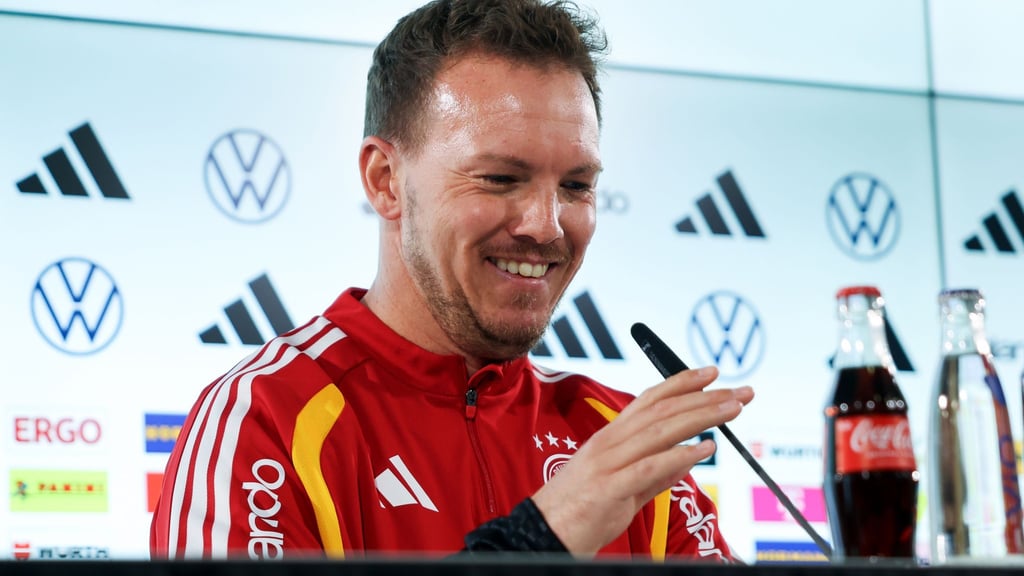 Julian Nagelsmann richtet das Mikrofon bei der Pressekonferenz.