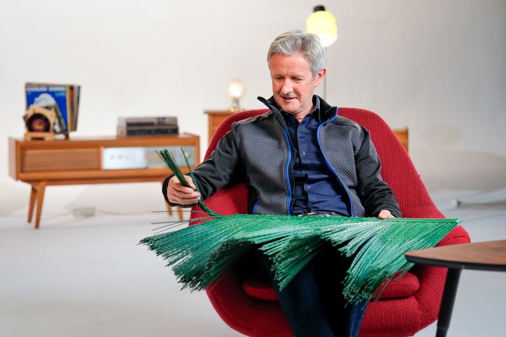 Skisprung-Olympiasieger Jens Weißflog zeigt eine Skisprungmatte, durch die das Training auch im Sommer möglich wurde.