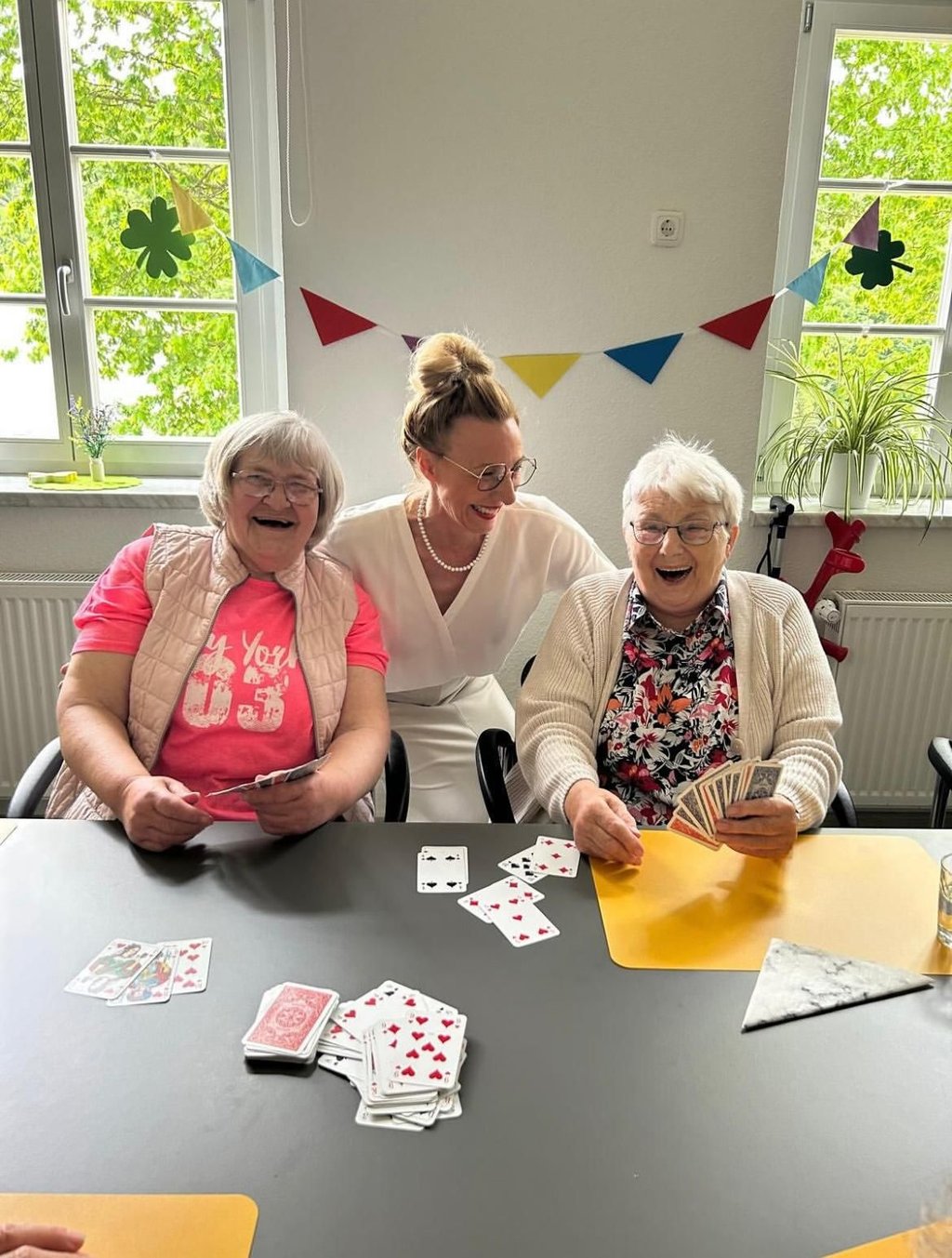 Seit Ende 2022 ist die ehemalige Kita in Güntersberge Tagespflege. Auf dem Programm stehen verschiedene Aktivitäten. Auch Karten spielen die Senioren  - hier im Bild mit Sina Werner-Grzyb - gern.
